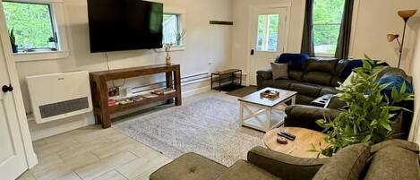 A living room with a sofa, a coffee table, a TV, and a fireplace.