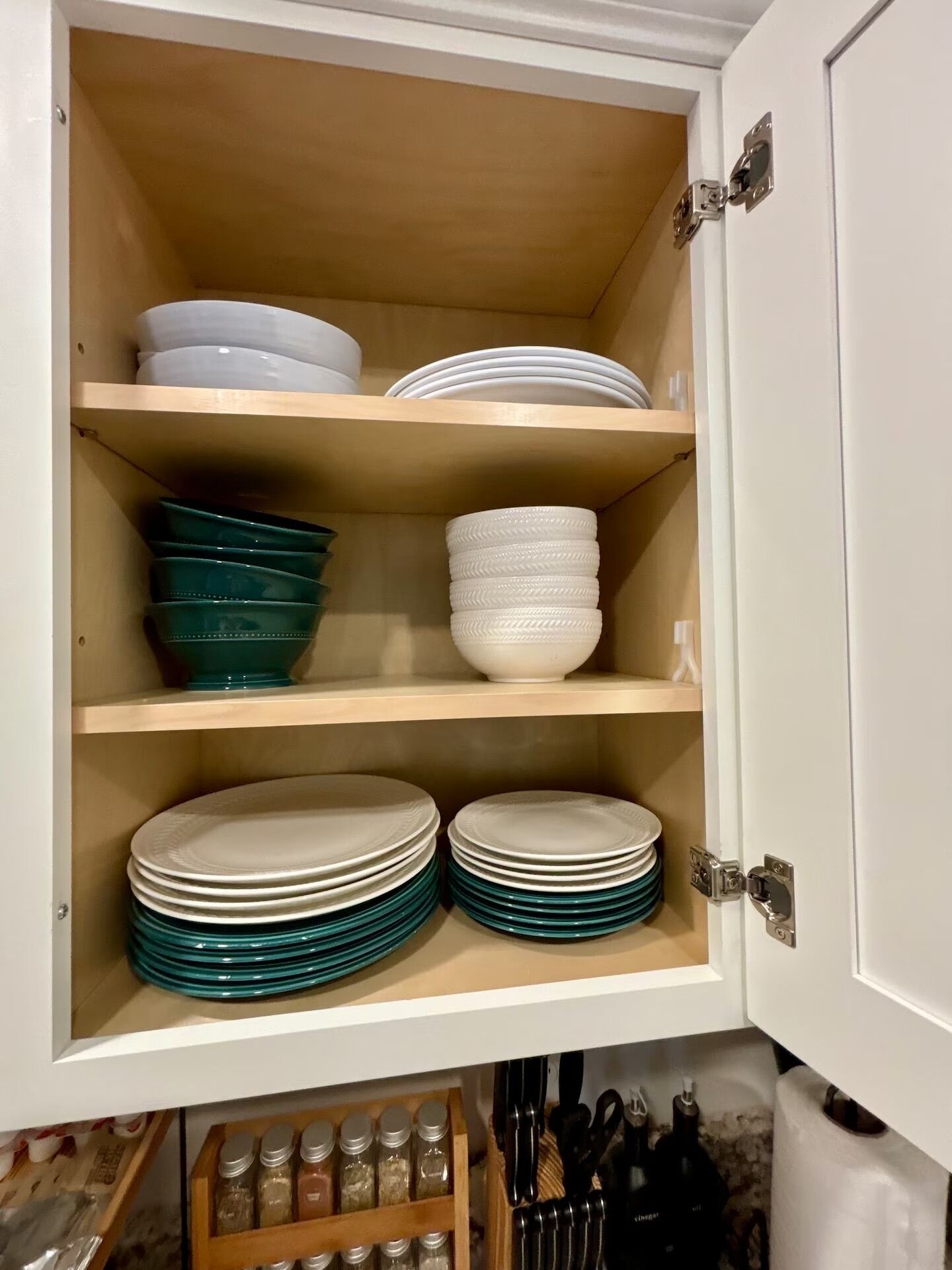 Un armario de cocina con estantes que contienen platos y cuencos.