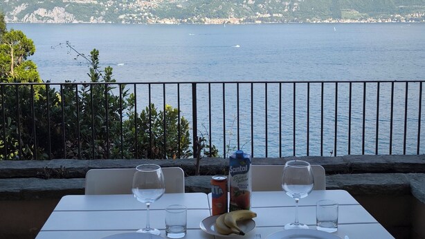A table set for two with a view of a lake and mountains. - View of Larian Triangle (Menaggio)