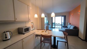 A modern kitchen with a microwave, dining table, chairs, and pendant lights. - View of Larian Triangle (Menaggio)