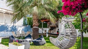A patio with outdoor furniture, a hammock, and a potted plant. - Villa Nomia (Ksamil)