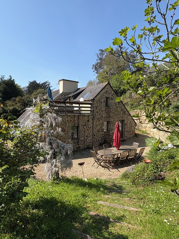 A stone house with a patio and outdoor seating.