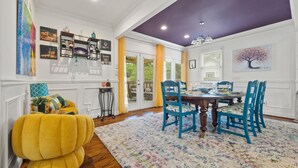 A dining area with a round table, blue chairs, and a colorful rug. - Spacious Atlanta Home – Sleeps 10, Kid-Friendly + Big Porch & Yard (Atlanta)