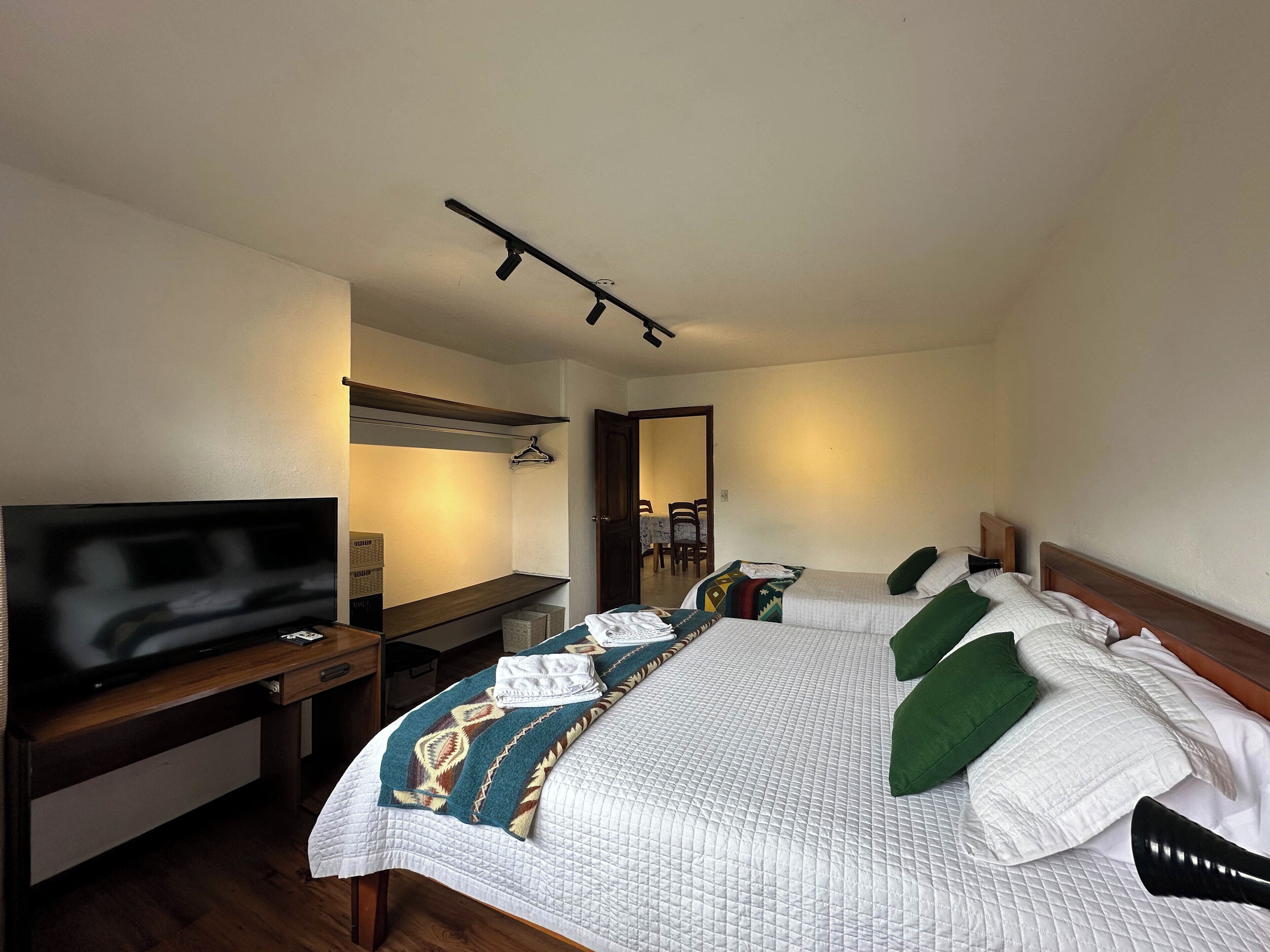 Une chambre d’hôtel avec un lit, une télévision, un bureau et un miroir.