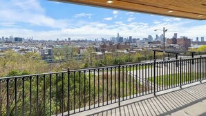 A view from a balcony with a cityscape in the background.