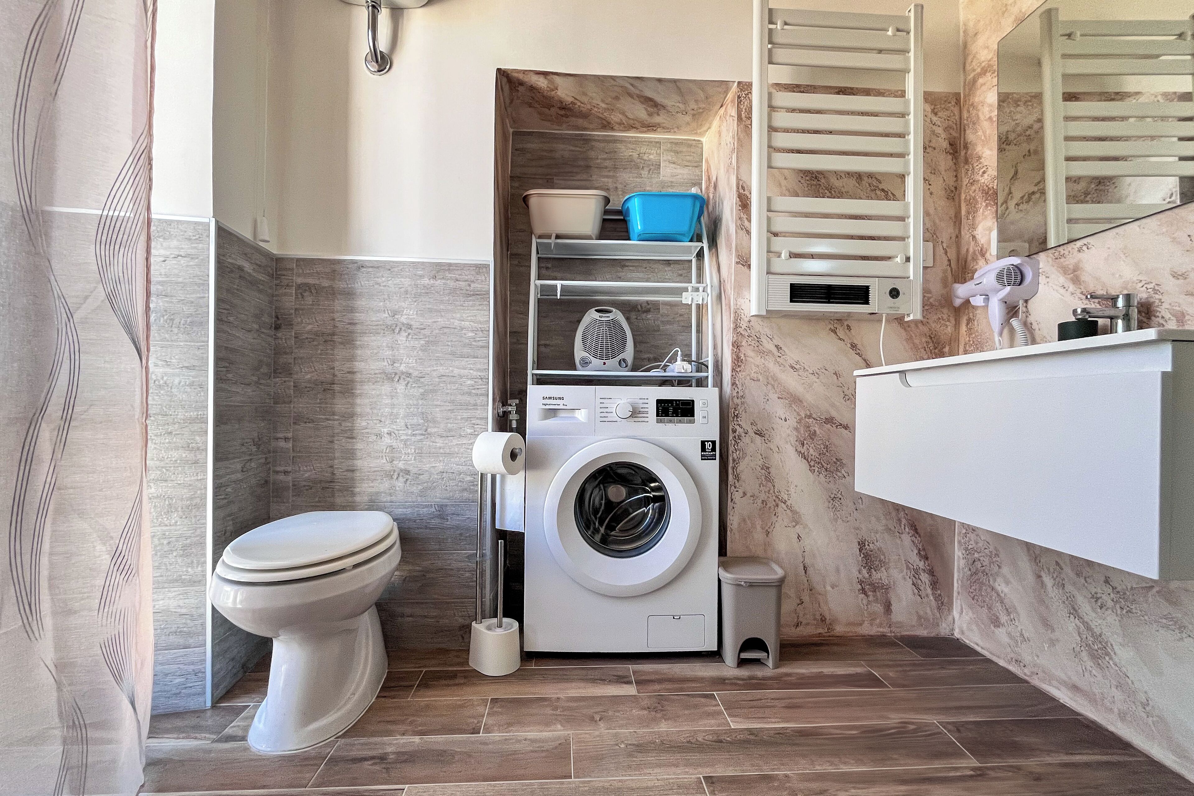 Un baño pequeño con inodoro, lavadora y lavamanos.