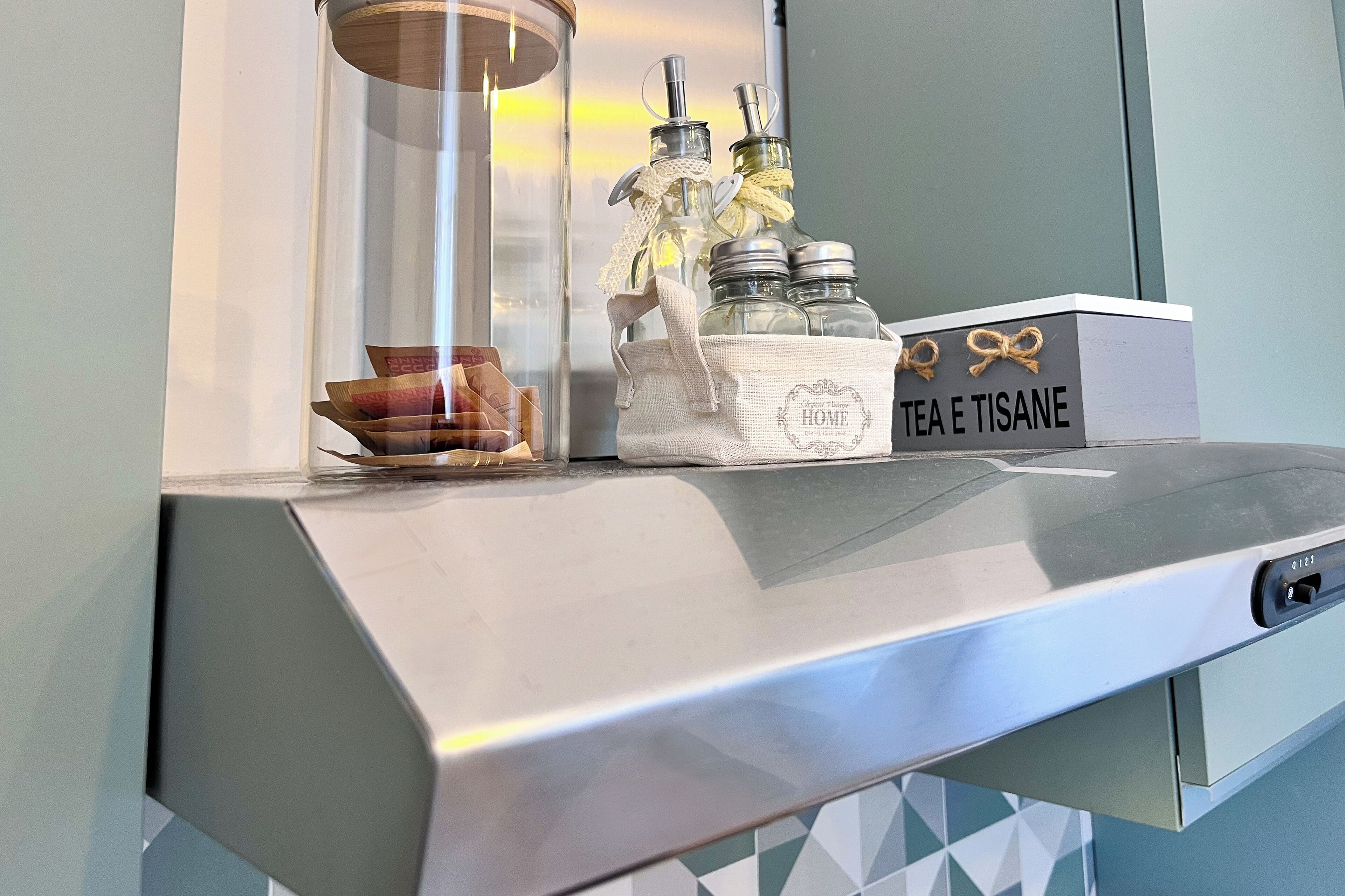 Eine Küchenarbeitsplatte mit einem Glasbehälter, einem Stoffbeutel und zwei Glasflaschen mit Metalldeckeln.
