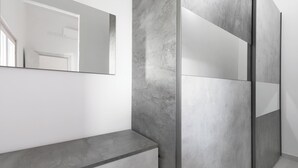 Een moderne badkamer met een grote spiegel, een marmeren wand en een minimalistisch ontwerp.