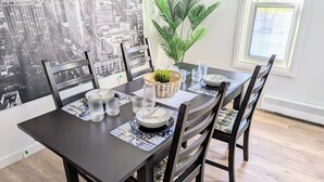 A dining table set with plates, glasses, and a decorative plant.