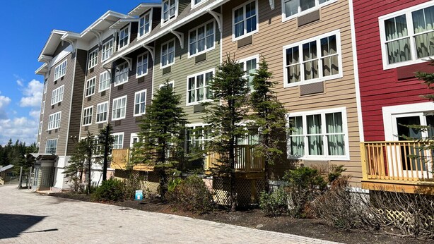 A multi-story residential building with a brick pathway leading to the entrance. - ES326 Super Cute Village Studio Condo Slope View (Snowshoe)