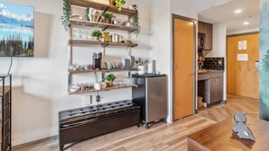 A modern kitchen with wooden shelves, a refrigerator, and a bench. - ES326 Super Cute Village Studio Condo Slope View (Snowshoe)