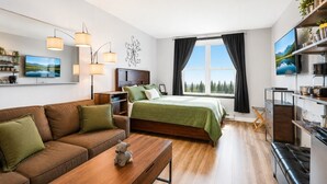 A modern hotel room with a sofa, a bed, a desk, a TV, and a kitchen area. - ES326 Super Cute Village Studio Condo Slope View (Snowshoe)