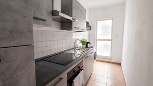 A modern kitchen with a black countertop, stainless steel sink, and a built-in oven. - Casa Olmedina - Studio Apartment, Sleeps 2 (Olmedo)