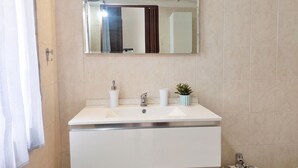 A bathroom with a white sink, a mirror, and a potted plant. - Casa Olmedina - Studio Apartment, Sleeps 2 (Olmedo)
