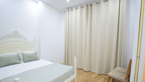Une chambre à coucher avec un lit, une chaise et une fenêtre avec des rideaux.
