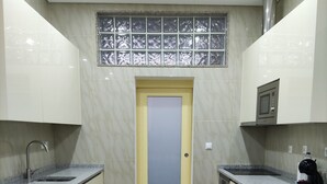 Une petite cuisine avec une nappe à carreaux, un four à micro-ondes et un évier.