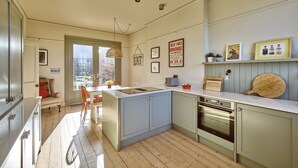 Una cucina moderna con un'isola centrale, un'area pranzo con vista e un piccolo spazio salotto all'aperto.
