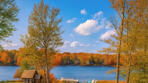 Une aire de jeux au bord du lac, avec une cabane en bois, des toboggans et des tables de pique-nique.