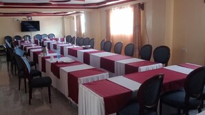 A conference room with long tables, chairs, and a television screen. - Sweet Bargain Hotel (Nakuru)