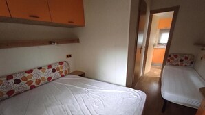 Un dormitorio con dos camas, cabeceros de madera y una mesita de noche.