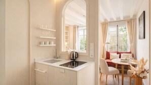 A modern kitchen with a sink, kettle, and shelves. - 1538 Visconti (Paris)