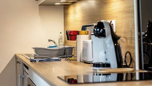 A modern kitchen with a microwave, coffee maker, and a wooden countertop.