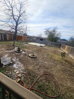 Enjoy an outdoor space with a deck, potted plants, and a basketball hoop.