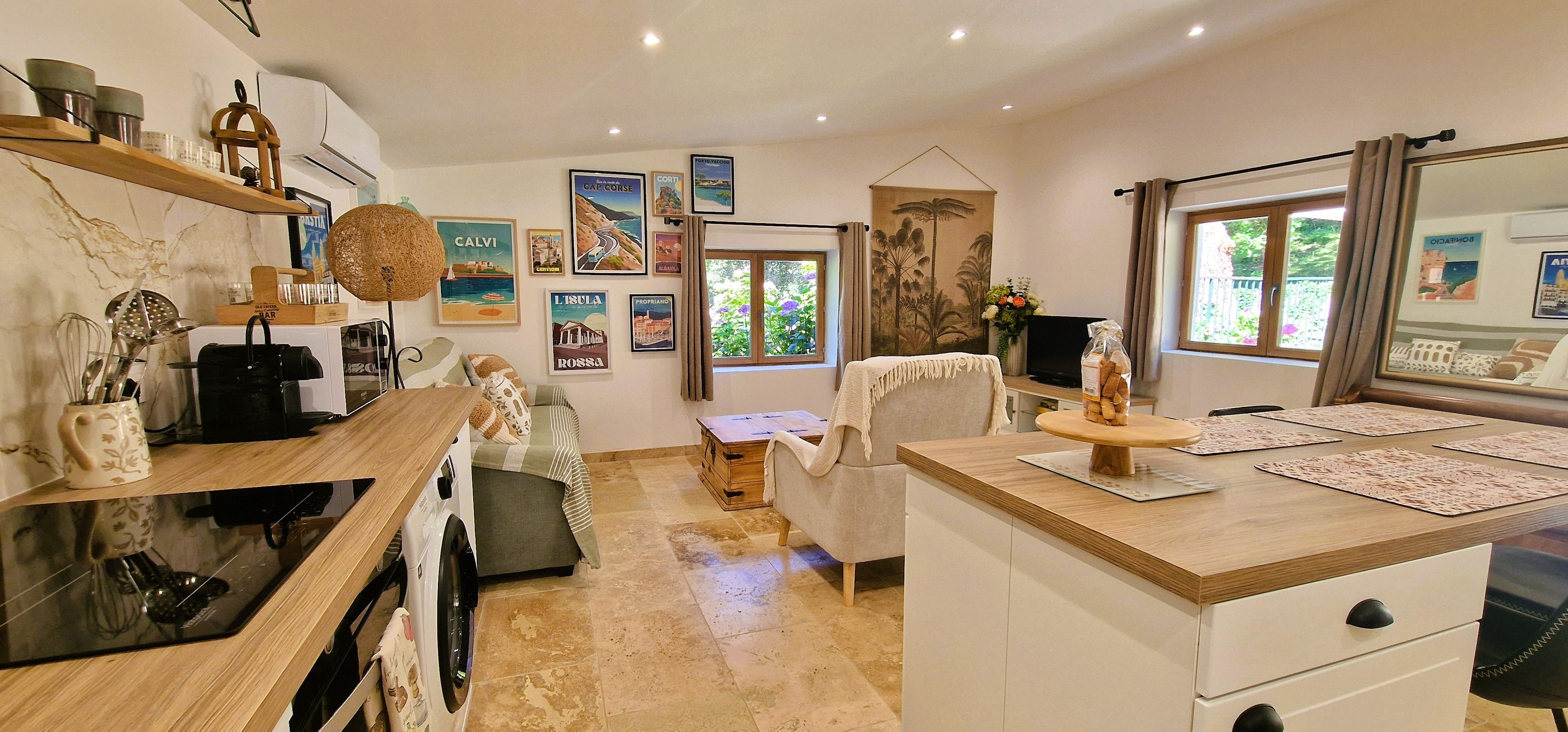 A kitchen with a microwave, coffee maker, and a sink. There are framed pictures on the wall and a window with curtains.