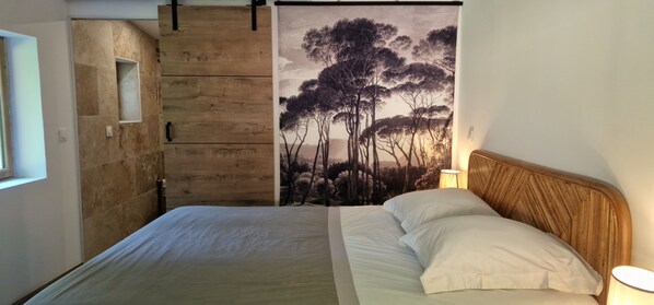 A bedroom with a bed, a wooden wardrobe, a wall-mounted shelf, and a painting of trees. - At Stalla in the mountains near a stream (Ortiporio)