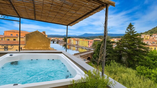 A hot tub with a view of a town and mountains. - Bosa Eye House 1873 (Bosa)
