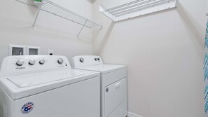 A laundry room with two Whirlpool washers, a metal drying rack, and a window. - 7BR Solterra Villa | Private Pool & Spa | Mickey Room | Near Disney (Davenport)
