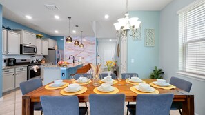 Una cocina moderna con gabinetes blancos, un microondas y un horno empotrado.