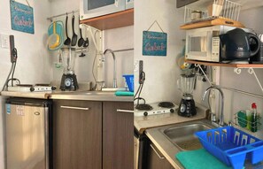 Cozinha compacta com geladeira, fogão, micro-ondas e pia.