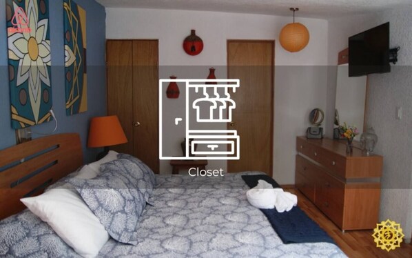 A bedroom with a bed, dresser, and wardrobe.