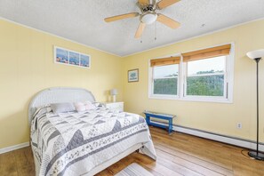 A bedroom with a bed, a ceiling fan, a window with a view, and a nightstand. - Serenity and Water fun abound in. this 3+ Bedroom on the Lagoon in Bayville! (Berkeley Township)