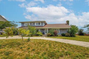 A two-story house with a front porch, a driveway, and a well-maintained lawn. - Serenity and Water fun abound in. this 3+ Bedroom on the Lagoon in Bayville! (Berkeley Township)