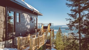 Une cabane en bois dotée d’une terrasse et offrant une vue sur l’océan.