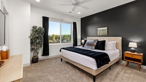 A bedroom with a bed, a nightstand, a lamp, a ceiling fan, a window with curtains, and a potted plant. - New- Pool, Hot Tub, Nintendo Switch, Pool, Pickleball and Ping Pong Fun (Santa Clara)