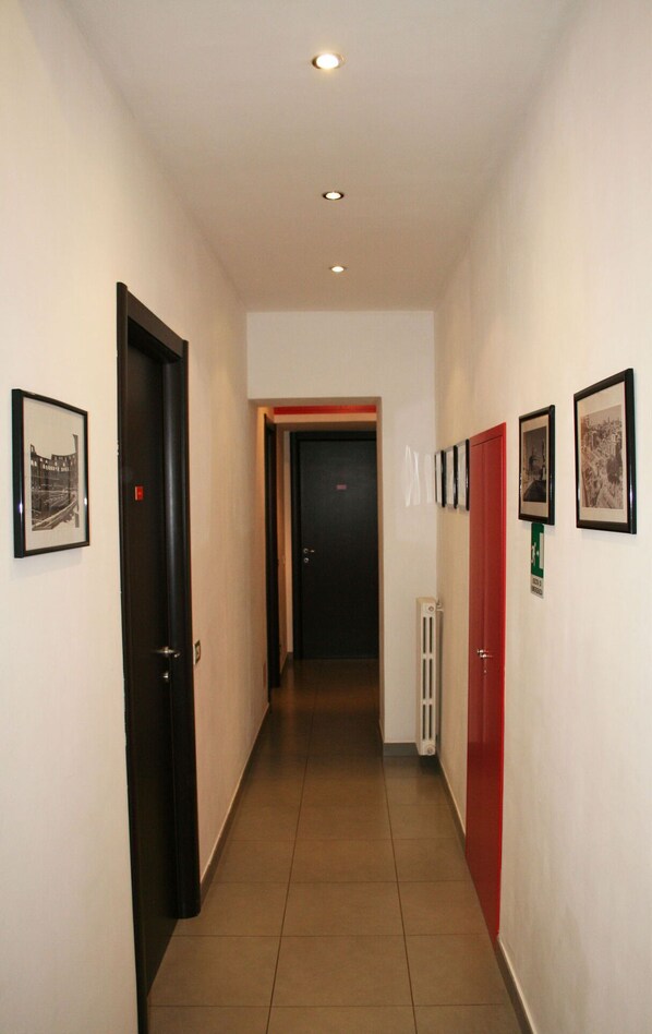 Stylish hallway with framed artwork and a door leading to a space.