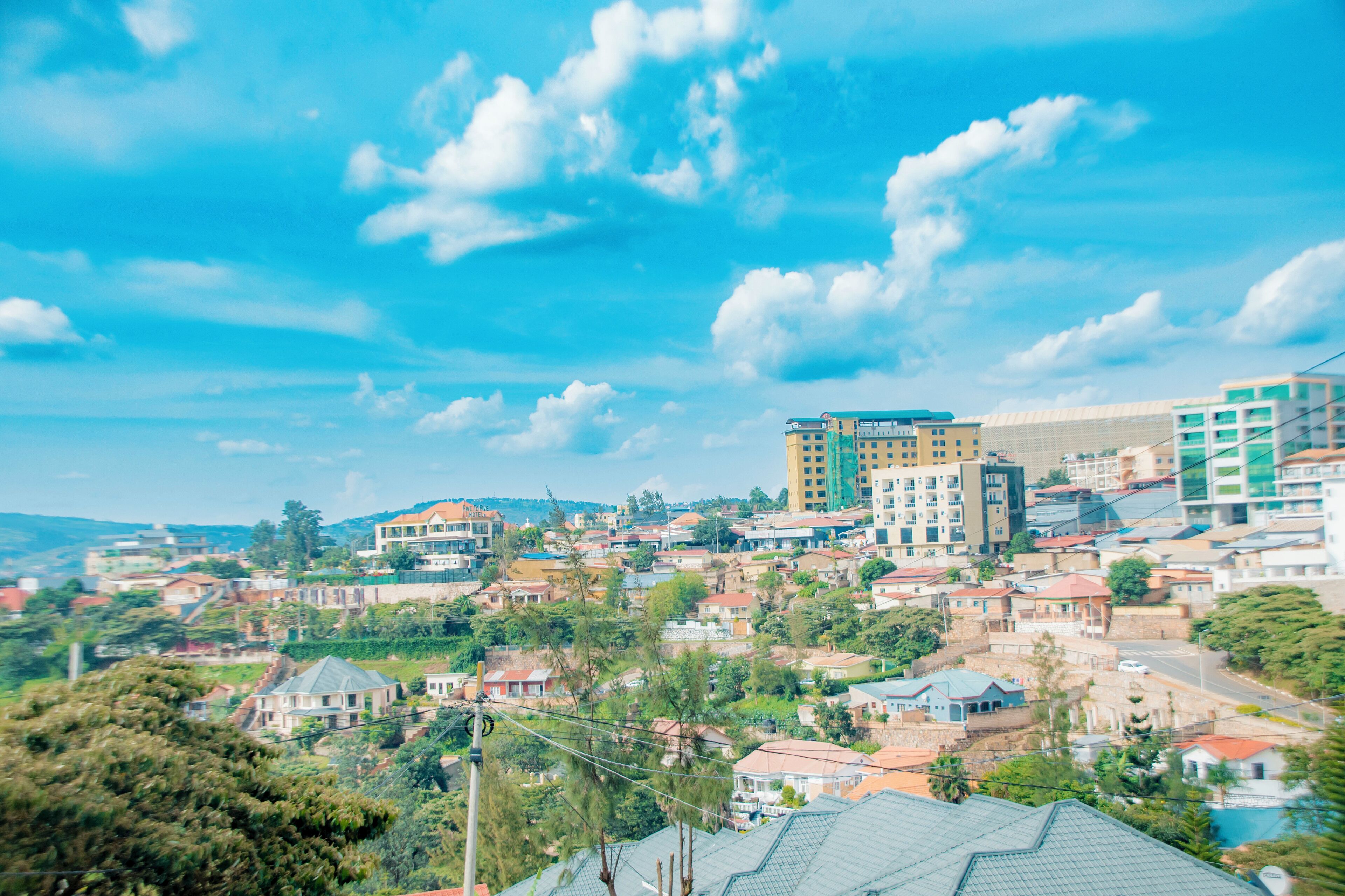 A residential area with various buildings, including multi-story structures and single-family homes, under a clear blue sky.