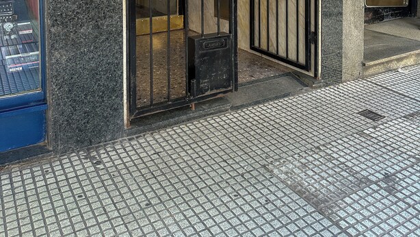 A building entrance with a metal gate, a tiled floor, and a visible number '1737' on the wall. - Rent Up -Monoambiente en zona tribunales (Buenos Aires)