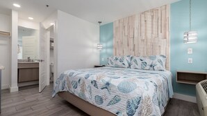 Een slaapkamer met een bed, een nachtkastje, een wandplank en een hanglamp.