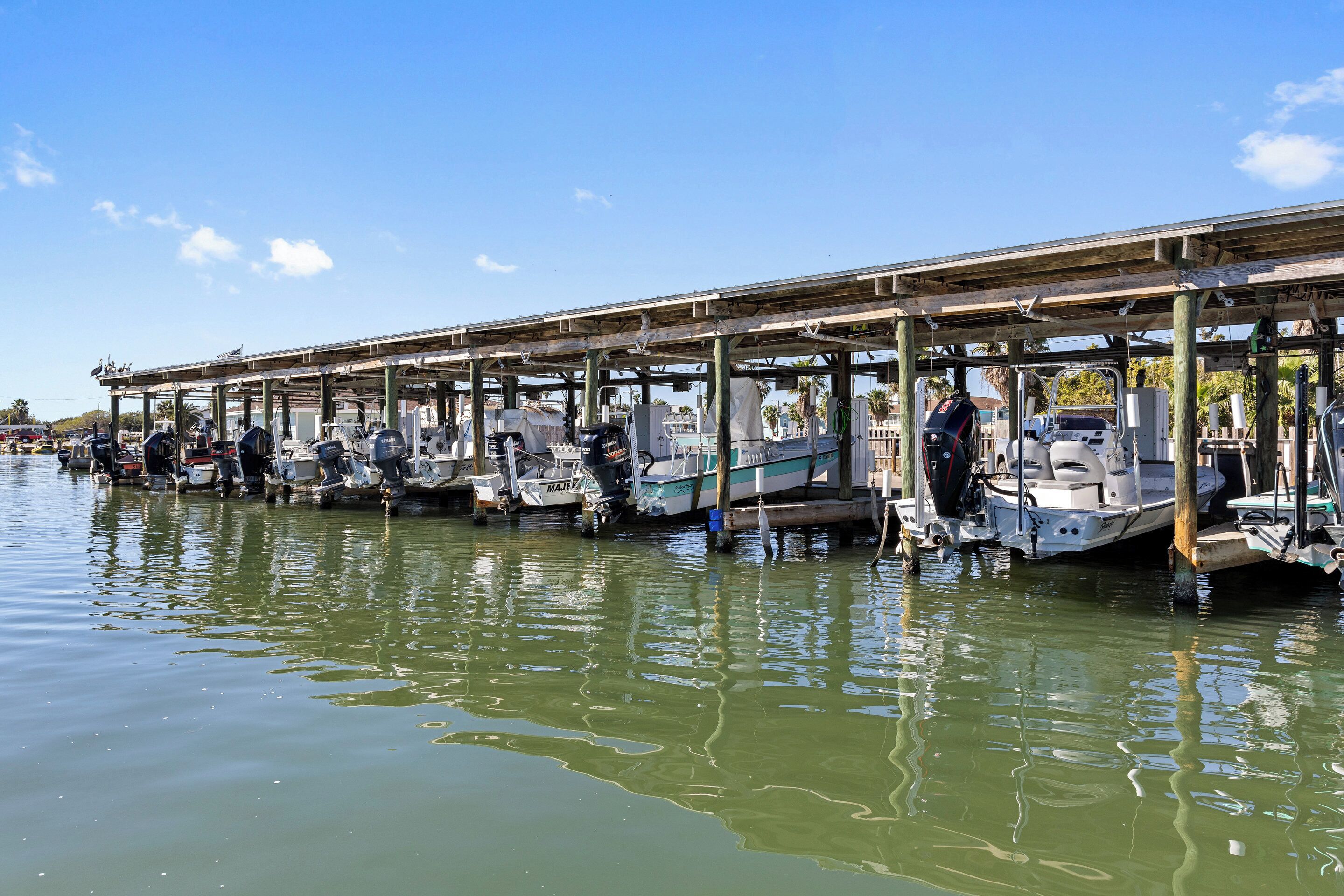 A marina with boats docked under a covered structure.