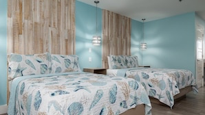 A bedroom with two beds, a striped wall, and a hanging light fixture.