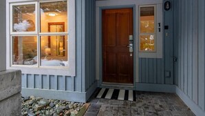 A house with a front door, a set of four windows, and a small porch area. - Updated Ski In 3-bedroom townhome in Whistler (Whistler)