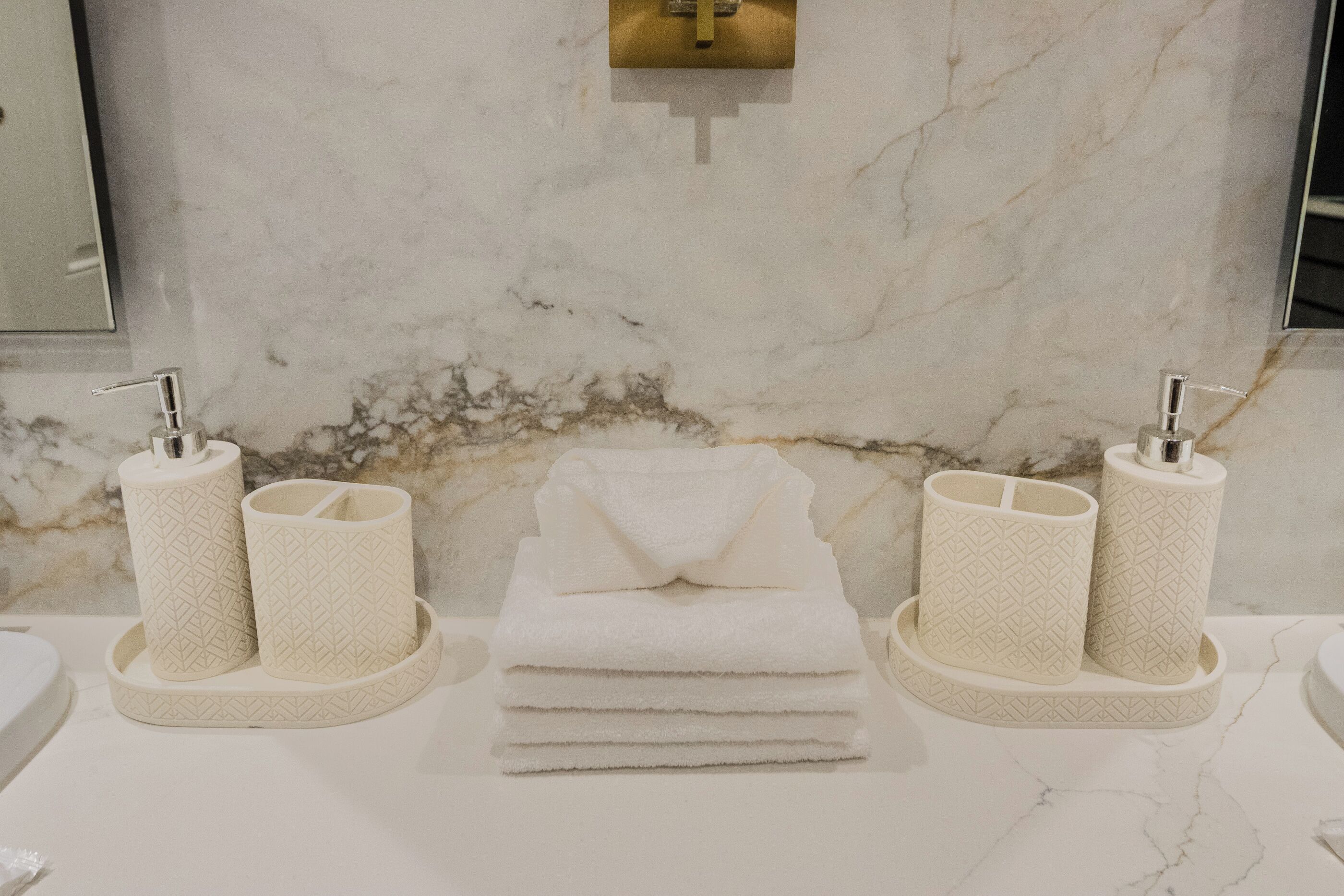 Ein Badezimmer mit Marmorwänden, zwei Waschbecken und Handtuchspendern.