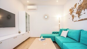 Un salon moderne avec un canapé de couleur turquoise, une table basse en bois et une carte du monde accrochée au mur.