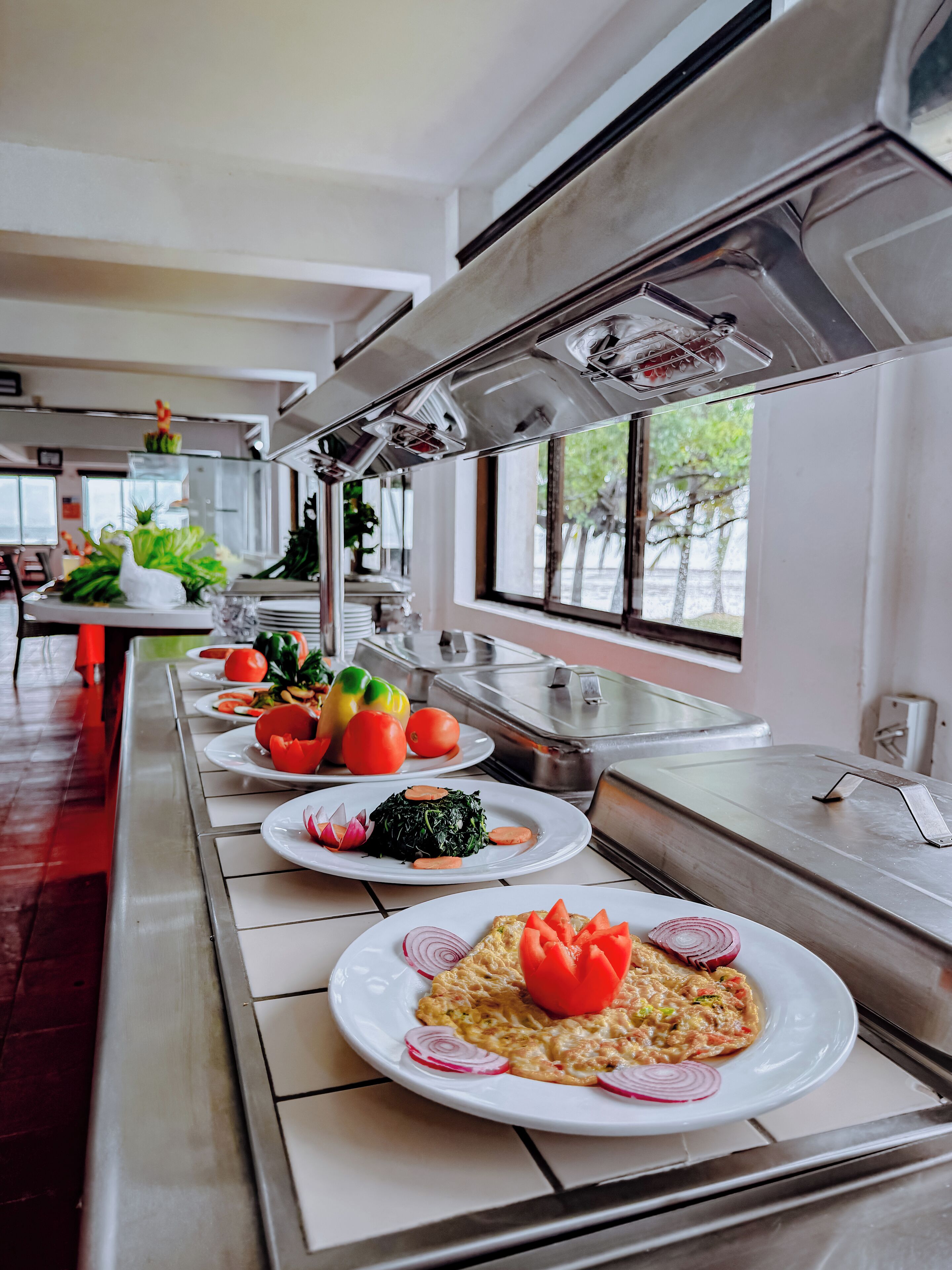 A buffet setup with various dishes and a window view.