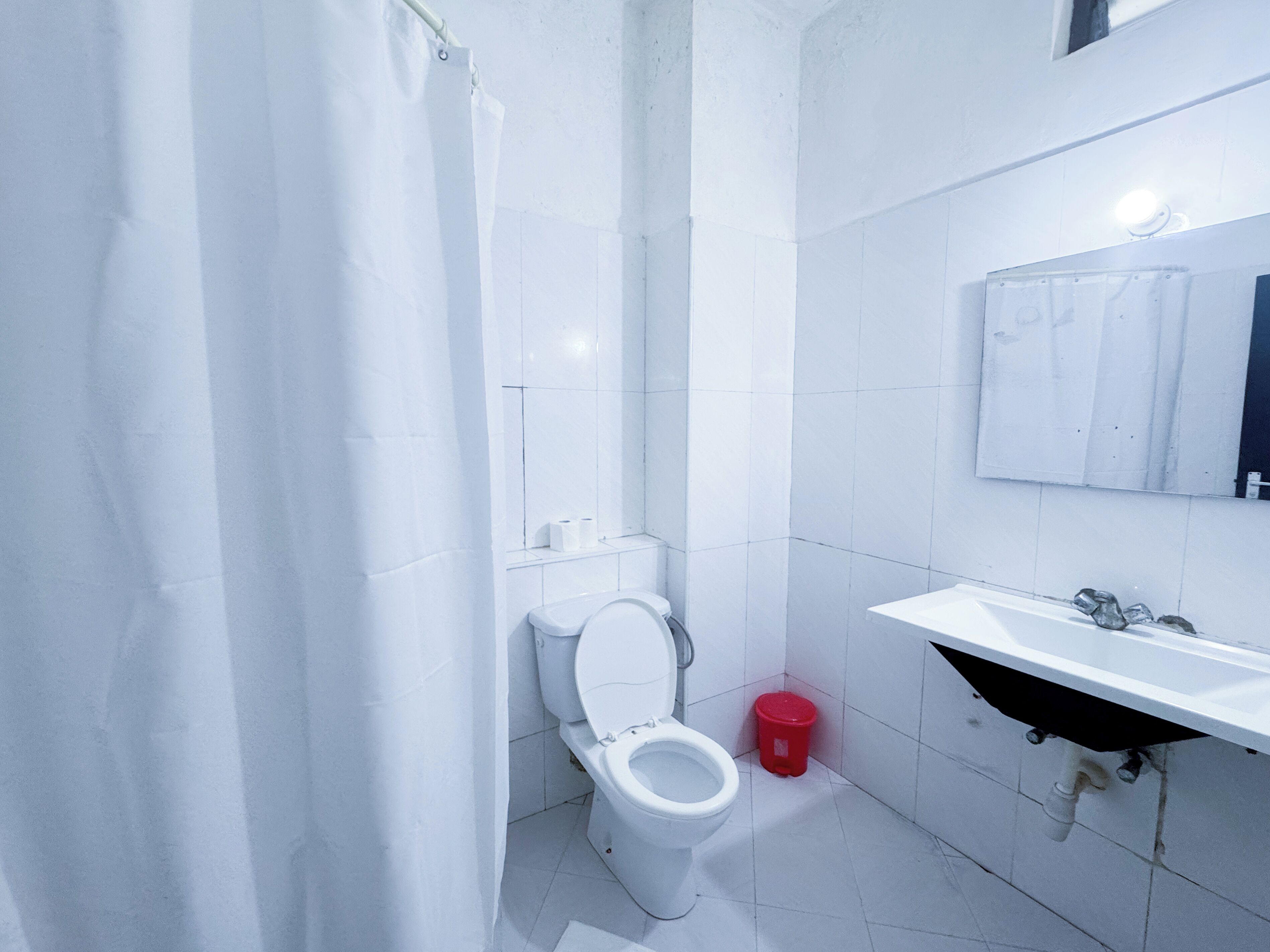 Un baño moderno con inodoro, lavamanos y espejo.