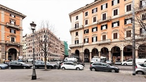 A street view with parked cars, historic buildings, and a lamppost. - Magic Guest House (Rome)